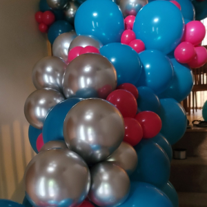 The initial assembly of a Qualatex balloon garland in bright blue, pink, and silver accents.