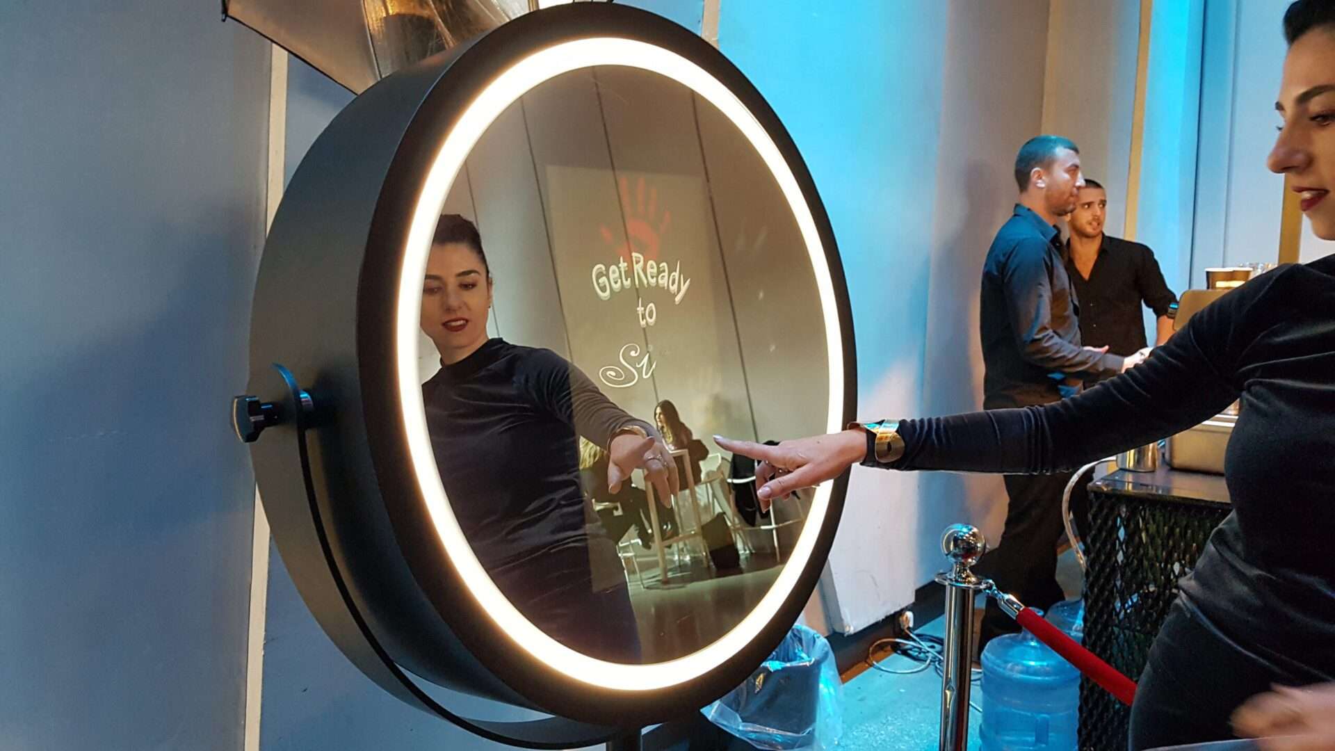 This is a picture of a woman using the beauty mirror photo booth as available to rent for all your special occasions from GBF Bespoke Balloons and Event Services.
