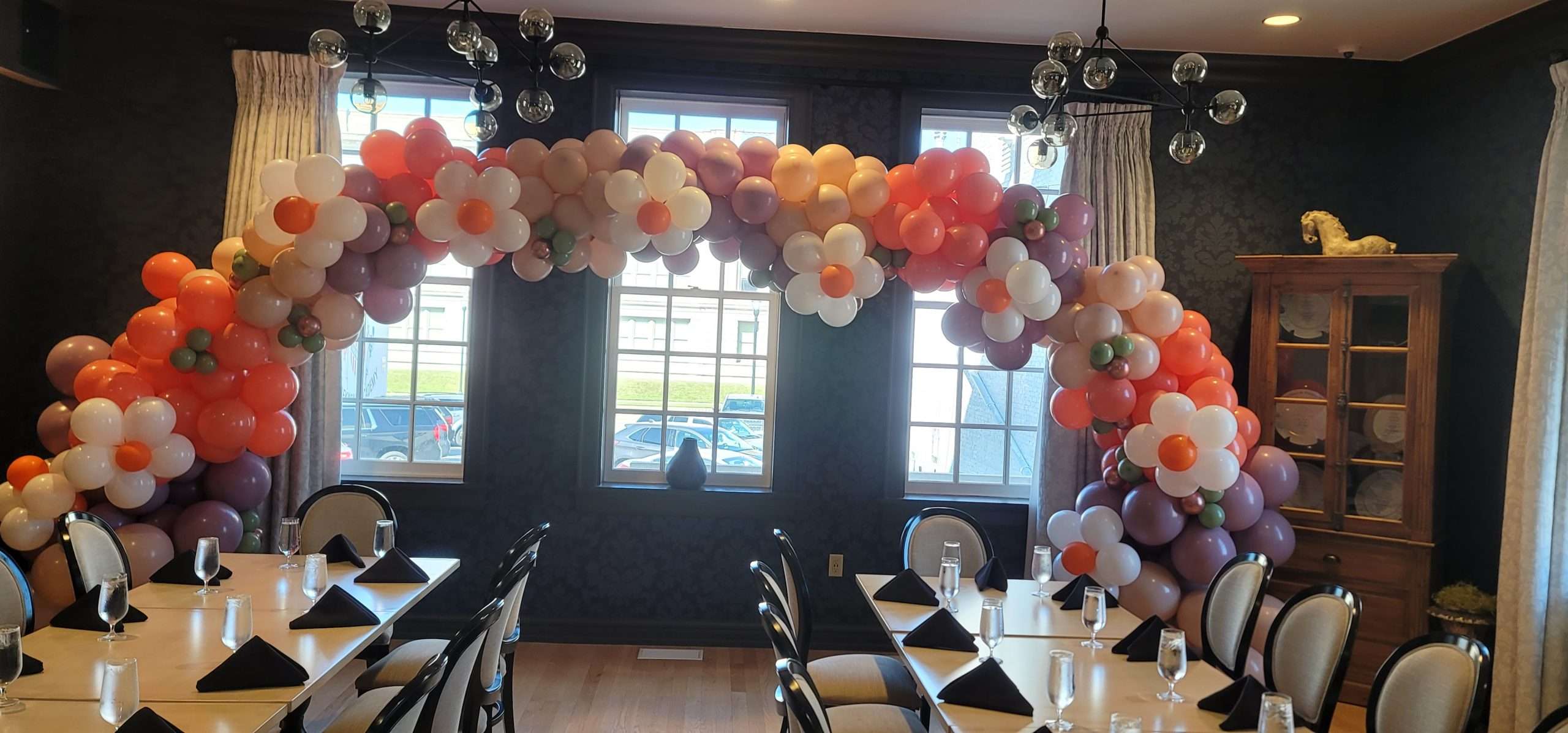 This is a beautiful organic balloon archway in lavender with daises in the design. There are flowers symmetrically throughout the organic balloon garland. This was made to coordinate with a baby shower and wildflower theme.