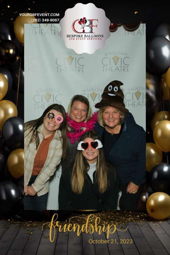 a photo from the beauty mirror photo booth by bespoke balloons. the photo shows four individuals with fun glassed and a poop emoji hat that were used as props for the photo booth picture.