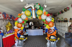Small Organic balloon arch featuring sports-themed foil balloons at GBF Bespoke Balloons and Event Services boutique.