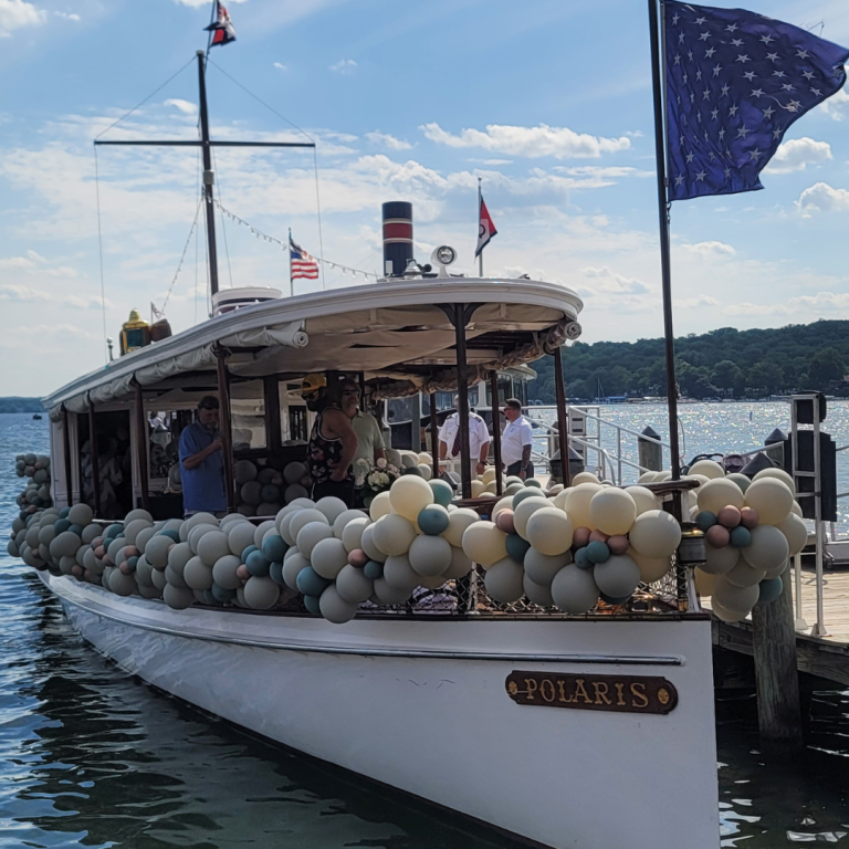 Sophisticated balloon garland in muted tones gracefully adorns the deck of the Polaris yacht on Lake Geneva.