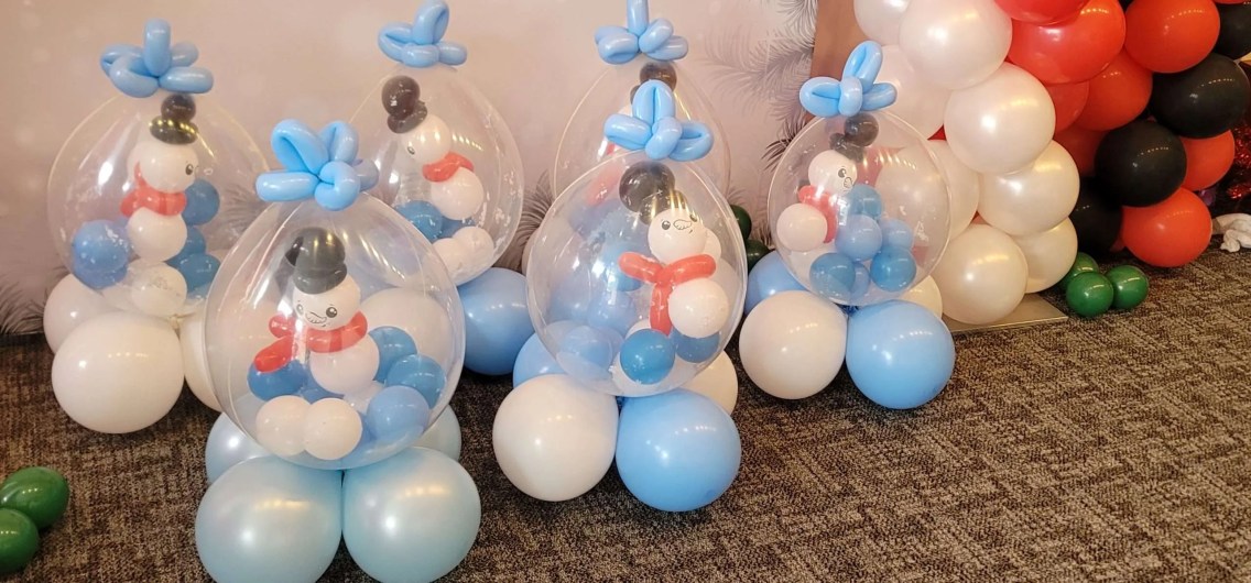This picture shows several oversized stuffed balloons with little balloon snowmen inside of the stuffed balloon. This stuffed balloon is similar to a snow-globe but much larger. The perfect decorations all of those winter months.
